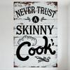 Vintage Rustic 'NEVER TRUST SKINNY Cook' Metal Tin Sign with Circular Emblem & Ornate Design, Distressed Wooden Plank Aesthetic