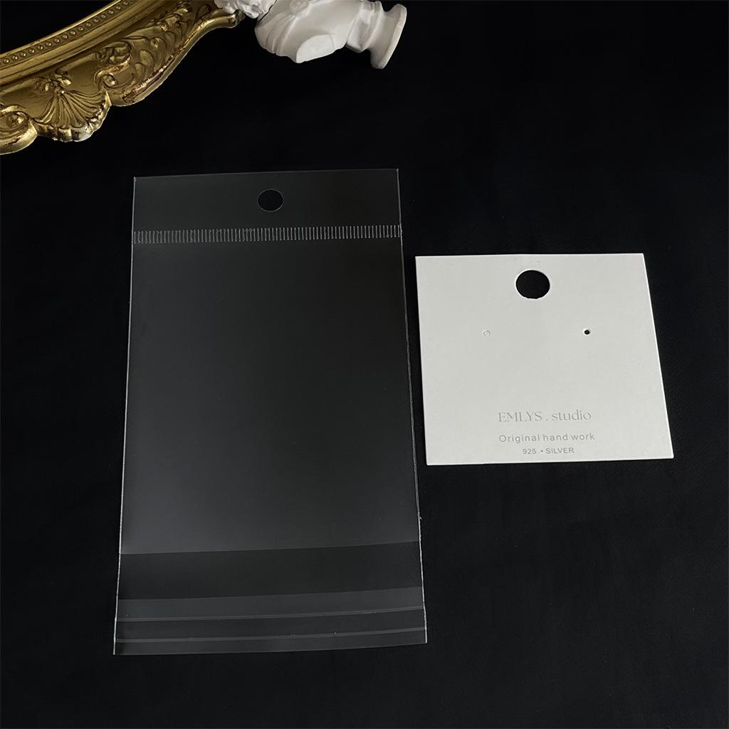 

Прозорий OPP пакет з картонною головкою білого кольору Потовщений OPP пакет з отвором для підвішування Квадратні геометричні сережки браслет Пакувальний пакет для зберігання прикрас Rectangular opp bag; single pack