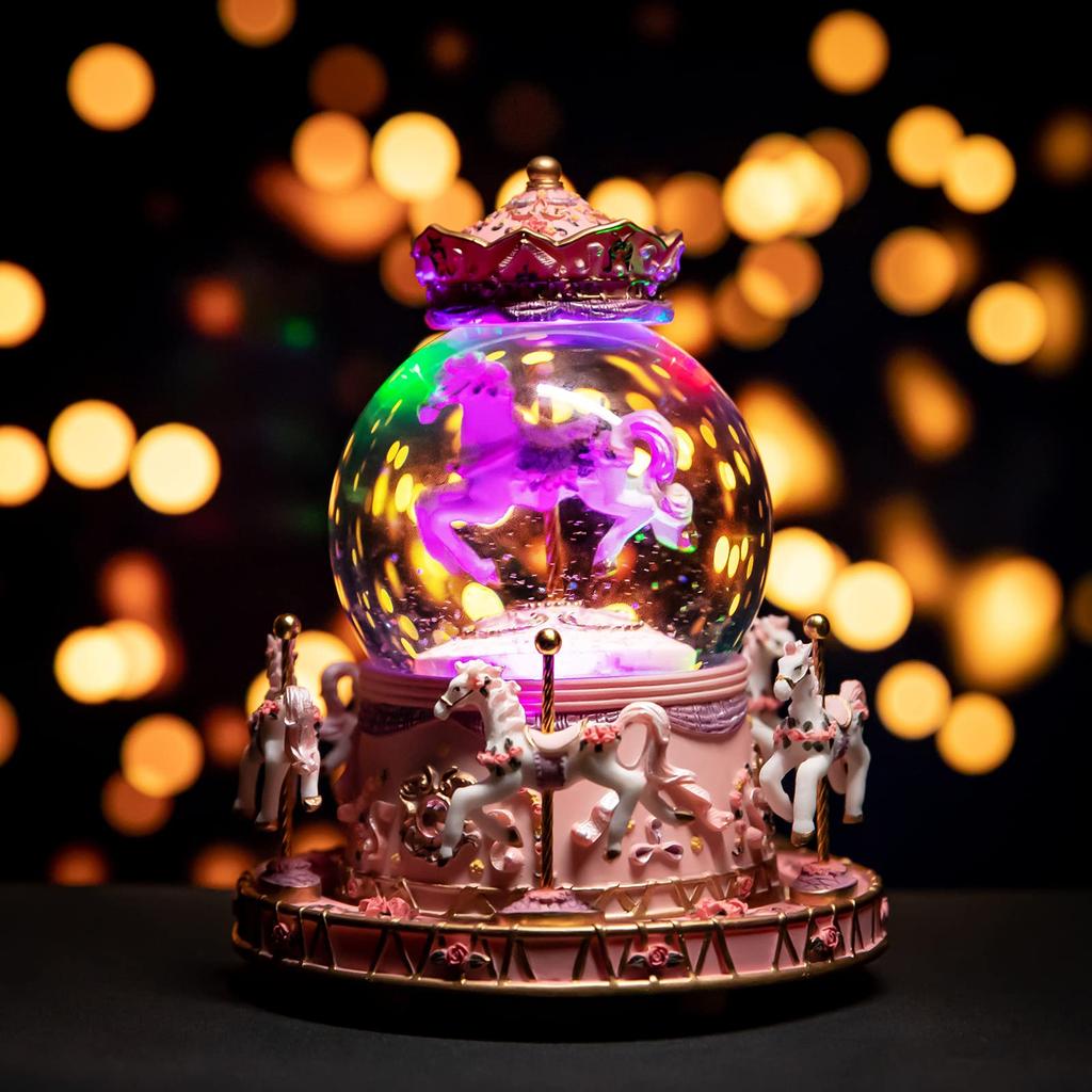 Snow globe music box with colored LED lights, merry-go-round, crystal ball, and automatic snowfall. Popular as a birthday or Christmas gift for girls,