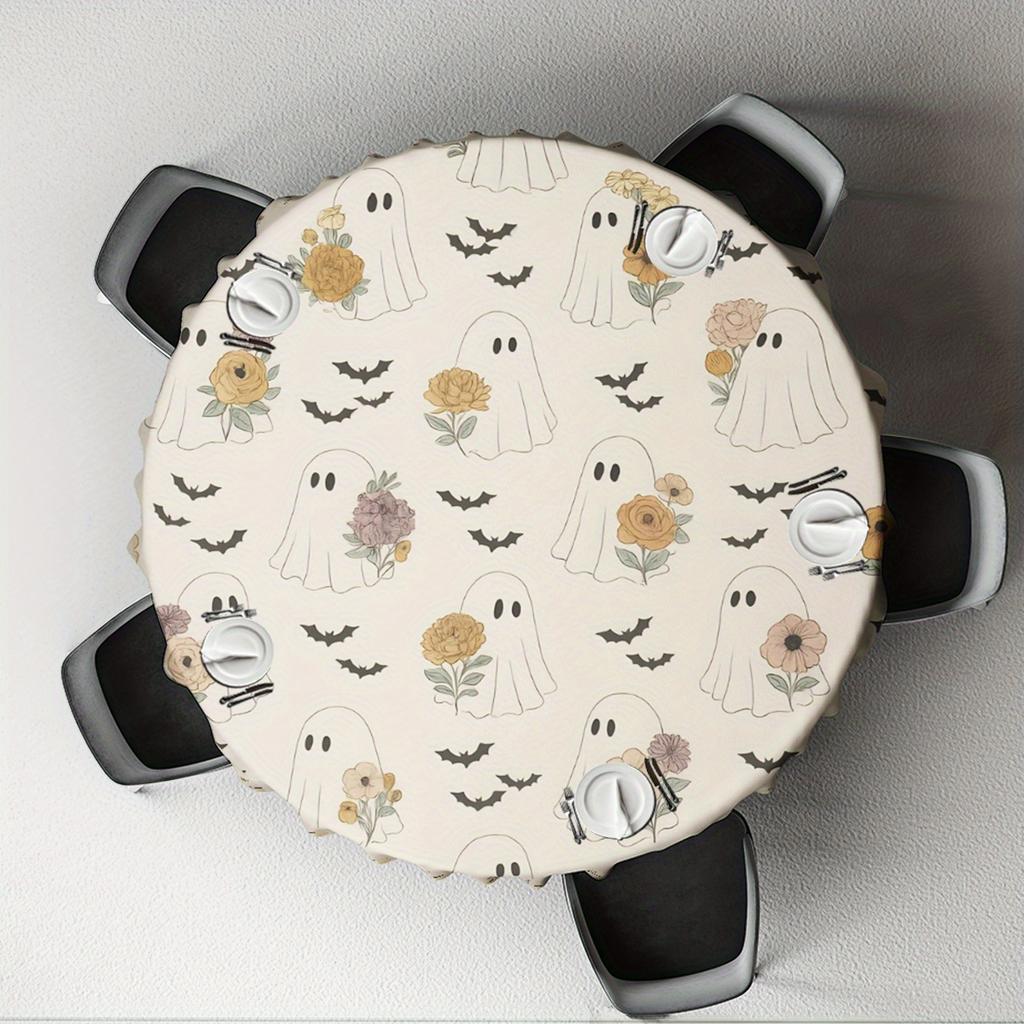 A vintage tablecloth with a Halloween theme, featuring ghosts and flowers.