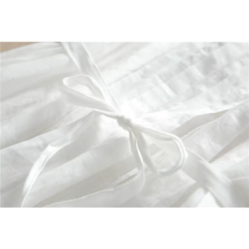 Eine Frau in einem weißen Kleid mit Schnürung und geraffter Taille