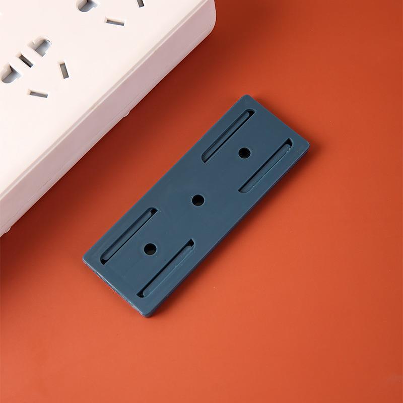 Nástěnný držák bez děrovače pro organizaci a vedení kabelů.