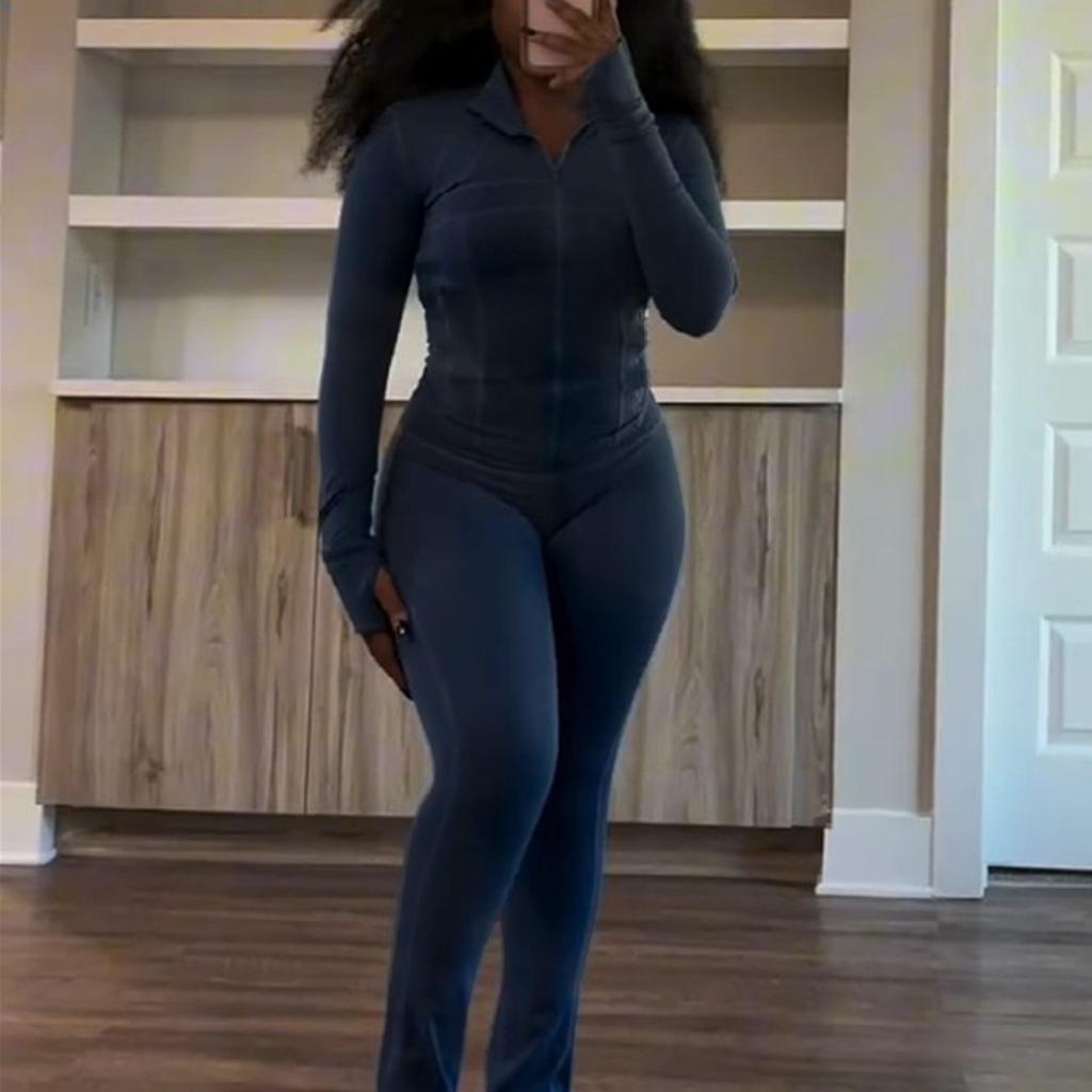 Weißer langärmeliger Jumpsuit mit Reißverschluss und ausgestelltem Bein